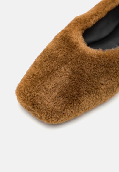 Brūna, ar pildījumu, slip-on tipa kurpe ar noapaļotu purngalu un mīkstu tekstūru. Mīksta iekšējā odere un minimālisma dizains.