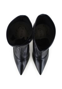 Stivaletti neri in pelle con punta affusolata, texture liscia, lati elasticizzati e design slip-on. Interno con dettagli del logo.