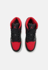 Black and red high-top basketball shoes with perforated toe box, black laces, and white sole. Iconic Jumpman logo on tongue and heel.