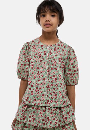 Blouse florale verte avec des manches bouffantes, ornée de fleurs rouges et roses et fermée par des boutons. L'ourlet froncé ajoute de la texture et du détail.