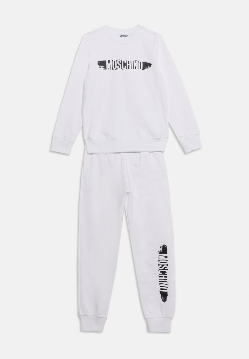 Λευκή σετ φούτερ και παντελόνι Moschino με μαύρο λογότυπο στο στήθος και αριστερό πόδι, εμφανισμένο επίπεδο σε λευκό φόντο.