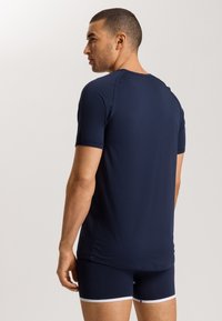 Navyblauwe sport t-shirt met korte mouwen, een gladde textuur en een aansluitend ontwerp, gedragen met bijpassende shorts met witte afwerking.