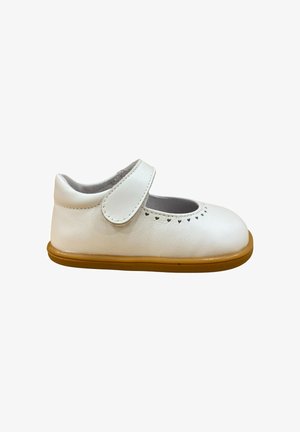 Zapato Mary Jane para niño pequeño de cuero blanco con perforaciones en forma de corazón cerca de la puntera y suela de goma marrón, cierre de velcro.