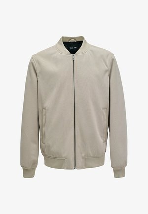 Giacca bomber beige con cerniera frontale, colletto, polsini e orlo a costine, tasche laterali, etichettata "Salsa Jeans" all'interno del colletto.