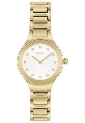 Guldfarvet metalur med en rund kasse, hvid urskive og diamantlignende timemarkører. Har et linket guldarmbånd og en krone til justeringer.