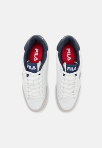 Vita lädersneakers med marinblå detaljer. Har platta snören, vadderad krage och röd inredning. Fila-logotyp på tungan och sidan.