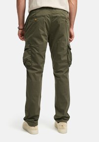Pantalones cargo verdes hechos de tela ligera, con bolsillos laterales, bolsillos traseros con cierres de botón y un corte relajado.
