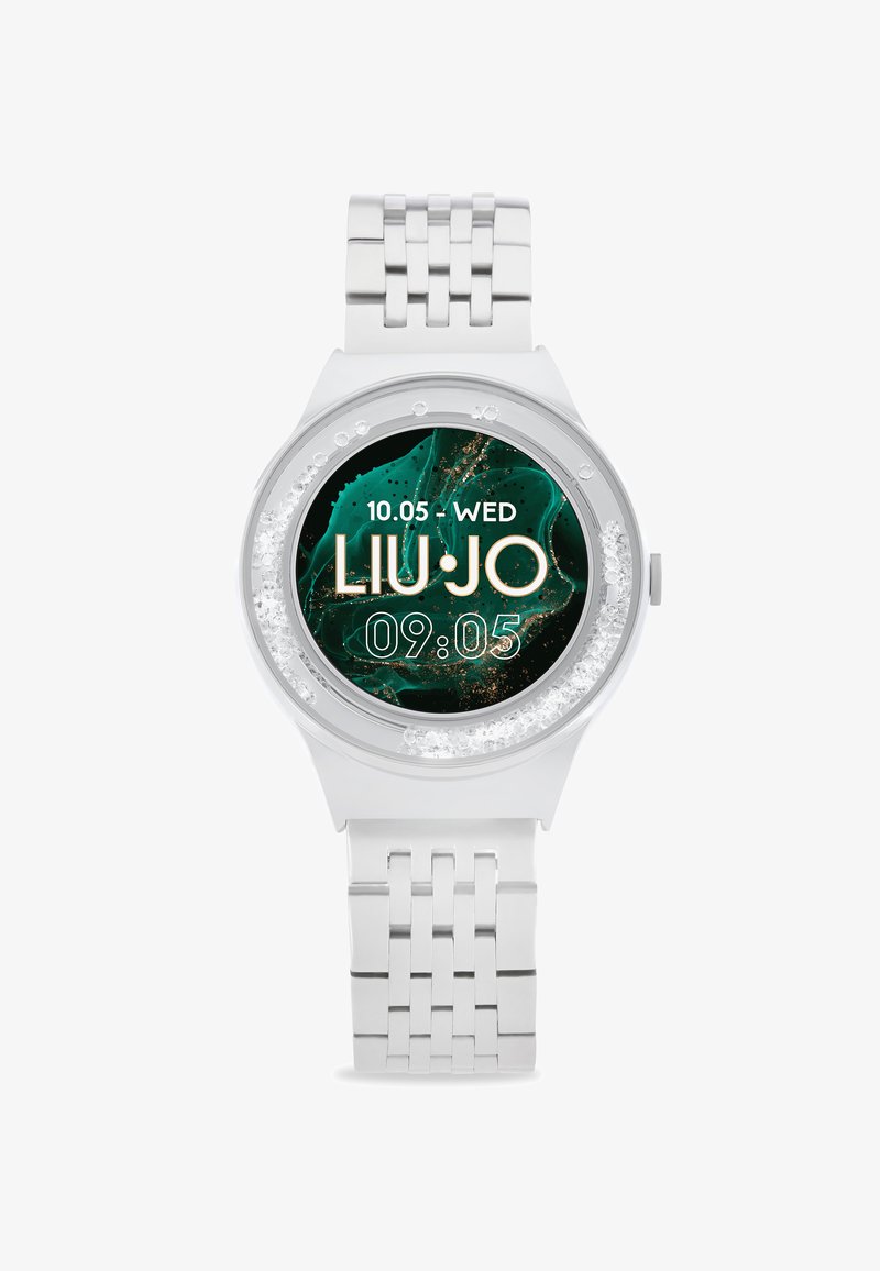 Sølv analog ur med en rund skive, der har en mørkegrøn marmorering som baggrund, gyldne detaljer og et tekstureret metalarmbånd.