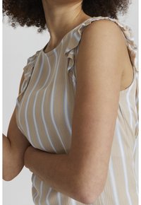 Top a righe beige con strisce blu, caratterizzato da bordi arricciati sulle spalle. Realizzato in tessuto leggero e testurizzato.