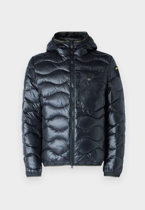 Giacca puffer nera trapuntata con cappuccio, caratterizzata da un tessuto lucido, una zip frontale e una tasca sul petto con zip. Dettagli in verde.