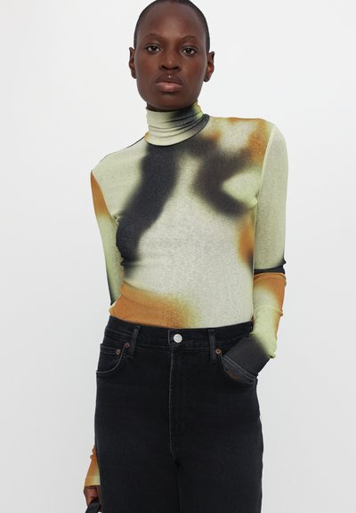 Long-sleeve, high-neck top featuring a blend of green, orange, and black abstract patterns; made of stretchy, smooth fabric.