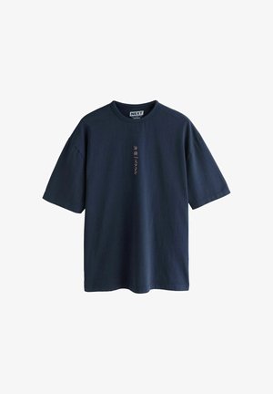 Marineblå T-shirt med afslappet pasform og korte ærmer, med lille lodret pink japansk tekst på brystet og rund halsudskæring.