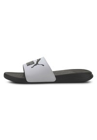 Chancla blanca con un logo negro, con una correa ancha y una suela texturizada negra. Diseño de punta redondeada con una textura de superficie suave.