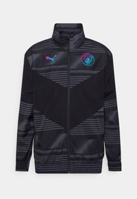 Black sports jacket with striped pattern, high collar, zip front, and Manchester City logo. Made of smooth, lightweight material.