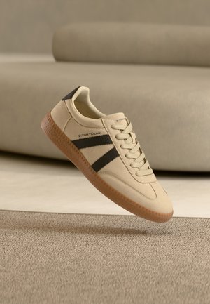 Tom Tailor Sneaker aus beigem Canvas mit schwarzen Streifen, Gummisohle und strukturierter Oberfläche, mit traditionellem Schnürdesign.