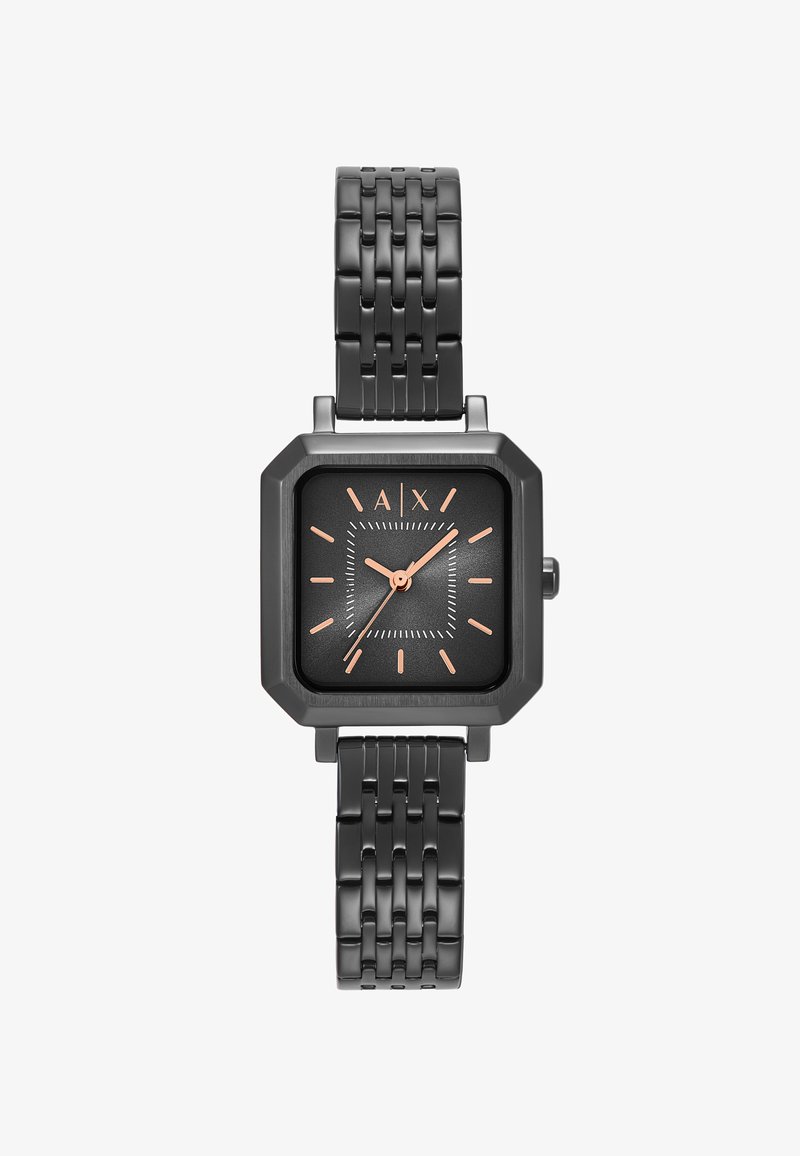 Kvadratisk svart klocka med en texturerad yta, rosaguldmarkeringar och ett vävt svart metallarmband. Har en minimalistisk design och tydlig läsbarhet.