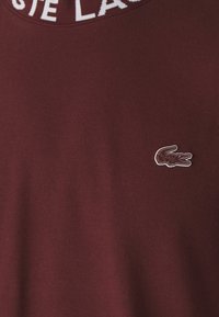 Lacoste CORE ACTIVE - Nyomott mintás póló - expresso
