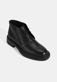 Schwarze Leder-Stiefelette mit strukturiertem Finish, Schnürdesign, runder Zehenform und einer strapazierfähigen Gummisohle mit geripptem Akzent.