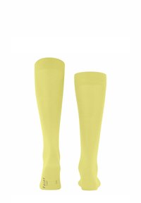 Calze compressive al ginocchio di un vivace giallo. Realizzate in un materiale elastico e liscio con una texture a costine e un logo discreto sulla suola.