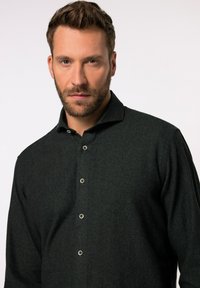 Donkergroene, langemouwenshirt van gestructureerde stof met een button-down kraag en vier contrasterende knopen aan de voorkant.