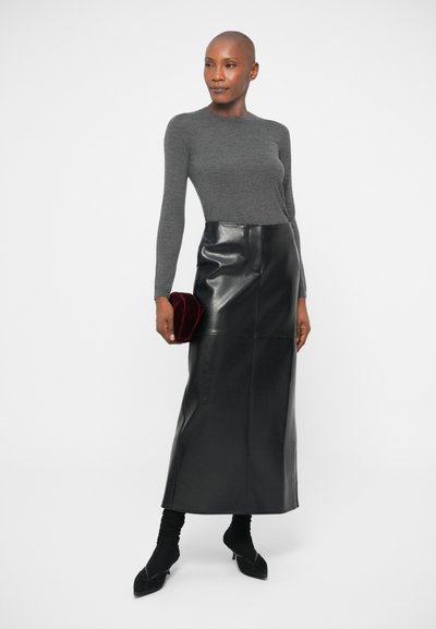 Siva prilega dolg rokav s sploščenim črnim usnjenim maksi krilom z visokim pasom. Drži majhno rubinasto rdečo žametno torbico. Črne pete zaokrožajo videz.