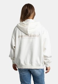 Bílá oversized mikina s kapucí na šňůrku a žebrovanými manžetami, s jemným logem "PEGADOR" v šedé barvě na zadní straně.