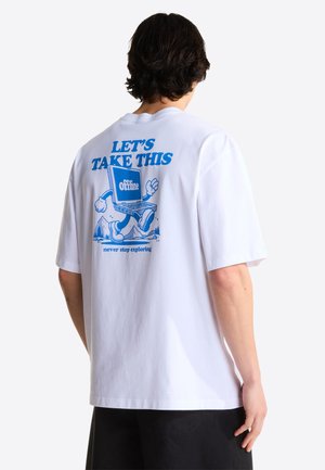Persona con una camiseta blanca con un gráfico azul de un portátil caminando y texto "LLEVEMOS ESTO fuera de línea" y "nunca dejes de explorar" en la parte posterior.