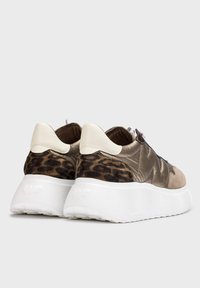 Zapatillas que combinan cuero marrón, acentos de estampado de leopardo, una suela gruesa blanca y un detalle del talón en beige claro.