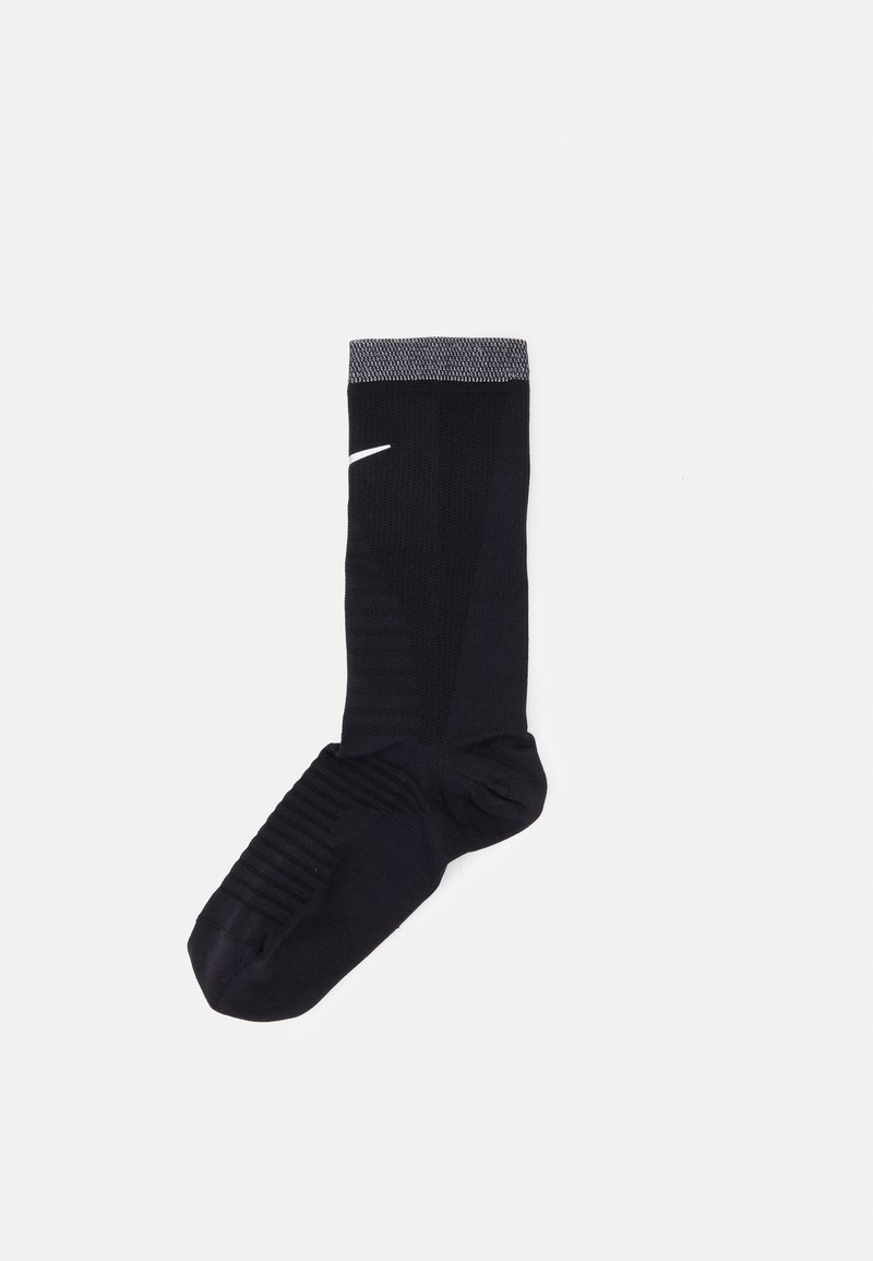 Black athletic sock with ribbed cuff, textured foot, and logo detail. Made from stretch fabric for comfort and durability.