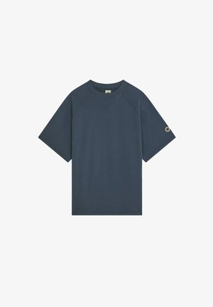 Sweat-shirt bleu marine à manches courtes avec un col rond côtelé et un petit détail métallique circulaire sur la manche gauche.