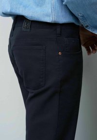 Diepnavy spijkerbroek met een slim fit. Kenmerken zijn onder andere een achterzak, tonale stiksels en een merklabel op de tailleband. Glad textuur.