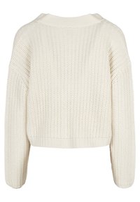 Vit, kort stickad tröja med lös passform. Har texturerat tyg, vida ärmar och ribbat nederkant och halsringning.