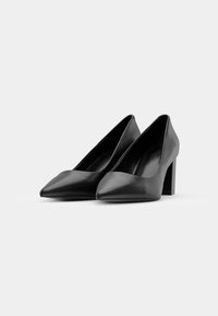 Scarpe nere in pelle con tacco alto, caratterizzate da una punta appuntita, design angolare e un tacco spesso con una texture liscia.