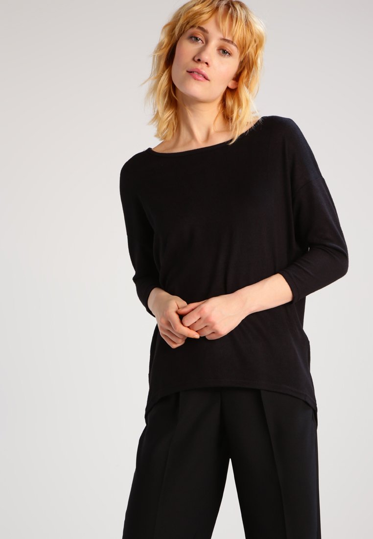 Maglione nero leggero in maglia con scollatura ampia e maniche a tre quarti, che cade morbidamente sul corpo. Texture liscia e vestibilità rilassata.