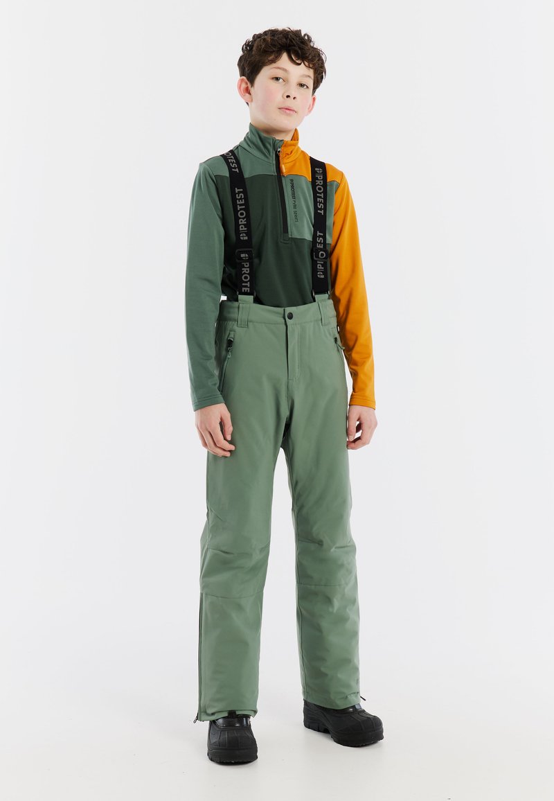 Groene waterdichte broek met verstelbare bretels en ritszakken, gecombineerd met een tweekleurig bovenstuk in groen en oranje. Heeft een hoge kraag.