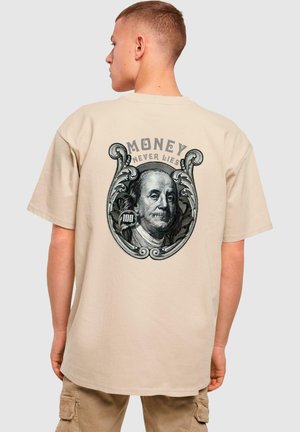 Beige cotton t-shirt featuring a large, detailed graphic of Benjamin Franklin on the back with the text "MONEY NEVER LIES" above it.