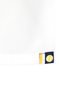 Witte geribbelde sportshirt zoom met een label dat een gele tennisbal logo op een marineblauwe achtergrond toont, verfraaid met gele en witte strepen.