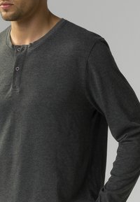 Ciemnoszara, długosleeve'owa koszulka henley wykonana z miękkiego materiału, z okrągłym dekoltem, trzema guzikami oraz luźnym krojem.