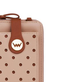 Light pink leather wallet with perforated pattern, accented by a brown leather tag and gold circular hardware featuring a logo. Zipper closure.