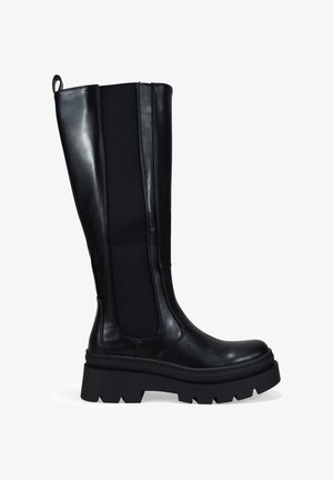 Bota de cuero negra hasta la rodilla con panel lateral elástico y suela gruesa de tracción, diseñada para uso casual o al aire libre.