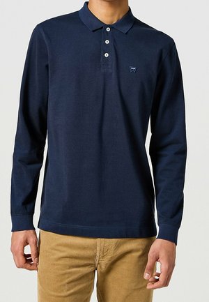 Polo à manches longues bleu marine en coton, avec une patte de boutonnage à deux boutons, un col côtelé et un petit logo sur le côté gauche de la poitrine.