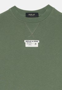 Sweatshirt vert en tissu texturé, avec un col rond, des coutures contrastées et une étiquette de marque avec "REPLAY & SONS."