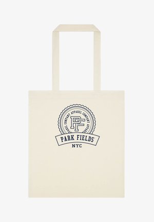 Beżowa torba na ramię z długimi uchwytami i okrągłym logo z napisem „Park Fields NYC” i „Apparel Company” w ciemnoniebieskim kolorze.