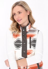 Gilet in pile con un motivo astratto in arancione, grigio e nero. Presenta un colletto alto, bottoni a pressione e una tasca con zip sul lato sinistro del petto.