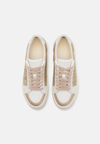 Baskets en cuir blanc avec des accents beiges et des panneaux latéraux texturés dorés. Elles présentent des lacets plats et un design à bout rond.