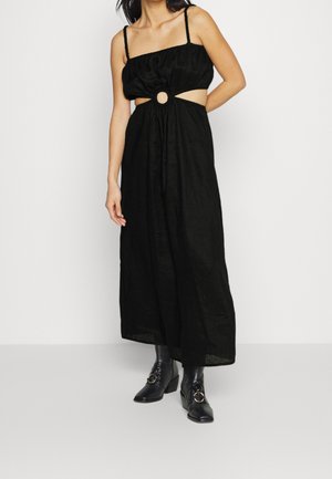 Robe maxi en lin noir avec un corsage ajusté, des bretelles réglables, un détail découpé orné d'un accent circulaire à la taille, et une jupe fluide.