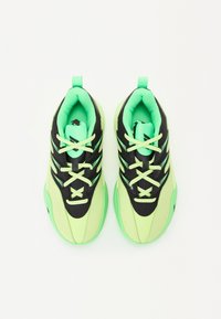 Des chaussures de sport noires et néon vert avec une tige en maille, des accents texturés et des lacets contrastants. Elles possèdent un col rembourré et une semelle en caoutchouc.