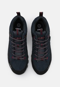 Chaussures de randonnée bleues en matériaux mesh et daim, avec des accents rouges et des semelles noires texturées. Équipées d'un système de laçage et de languettes de traction au talon.