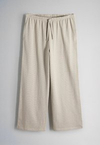Pantalon beige clair à jambes larges avec des rayures horizontales discrètes et une taille à cordon suspendu sur un fond uni.