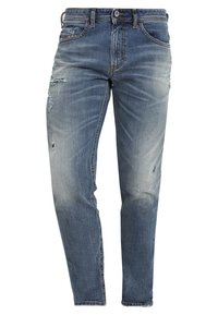 Blå denimjeans med en avslappnad passform, med slitna detaljer, blekning, fem fickor och en metallknäppning.